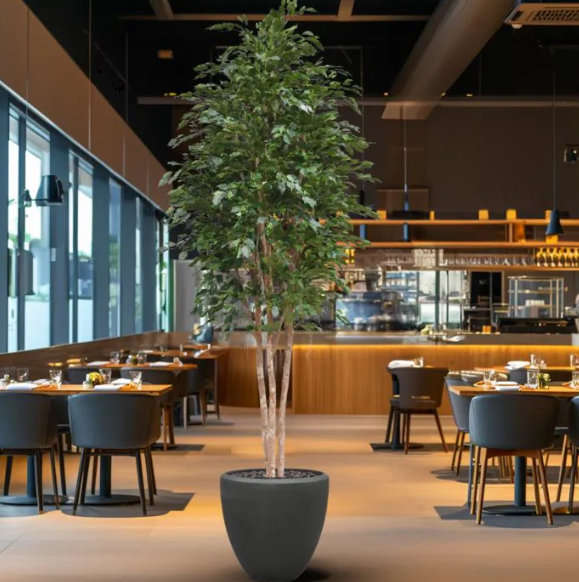 Moderne werkruimte met kunstplanten die zorgen voor een nette, duurzame en uitnodigende kantooromgeving.