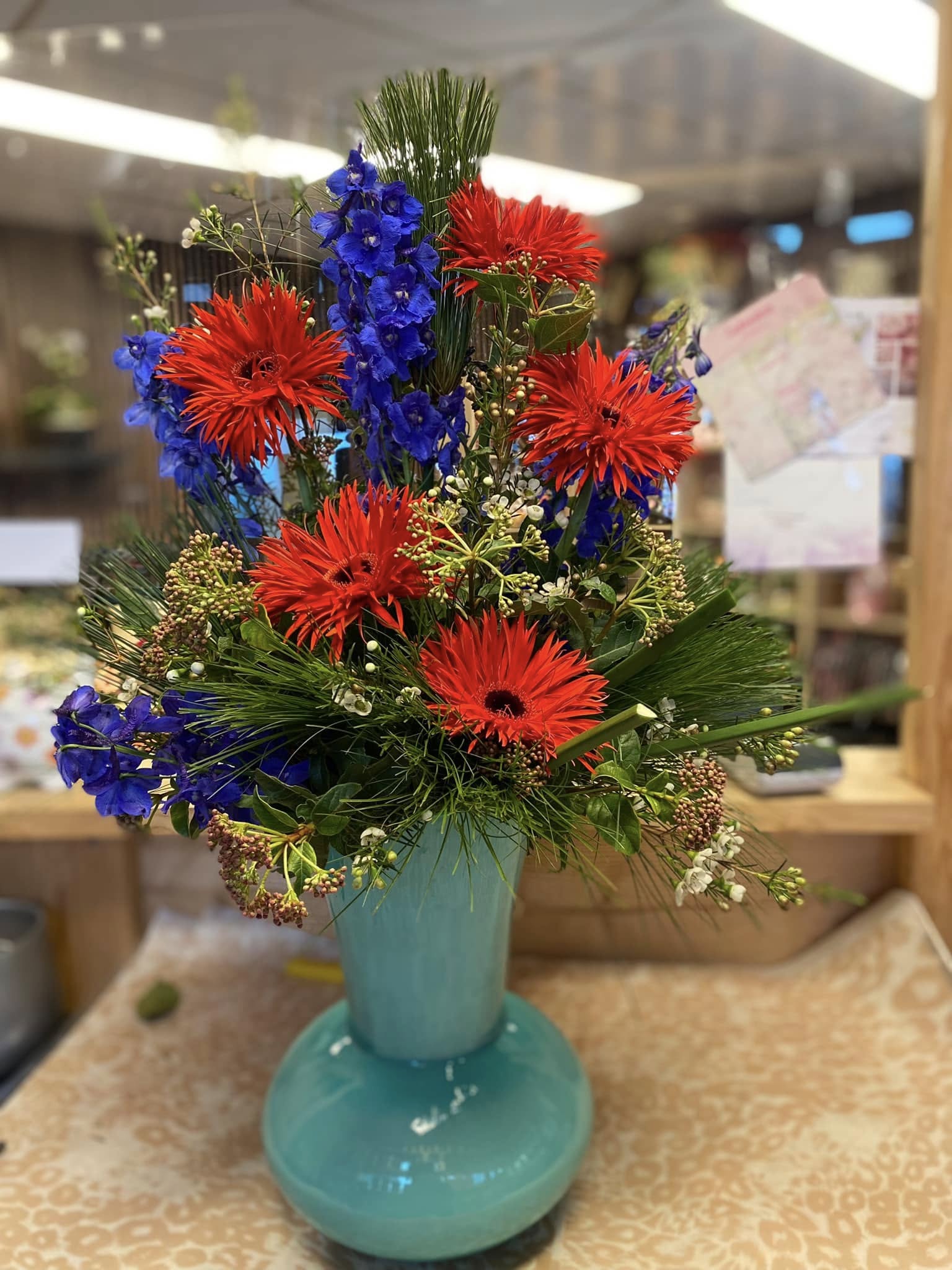 Modern zakelijk bloemstuk in een glazen vaas op een witte kantoorreceptie door Business Plants.
