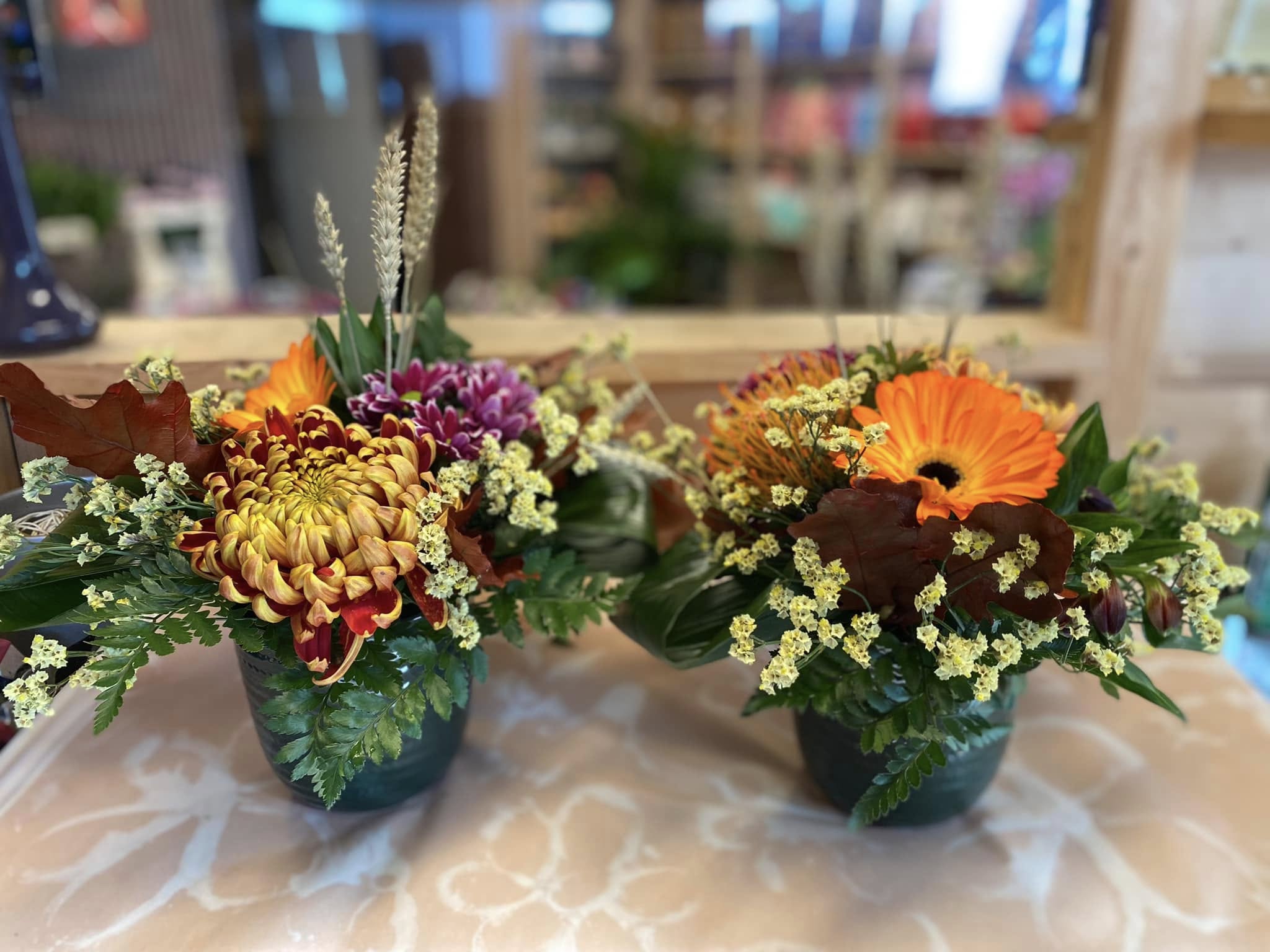 Modern zakelijk bloemstuk in een glazen vaas op een witte kantoorreceptie door Business Plants.