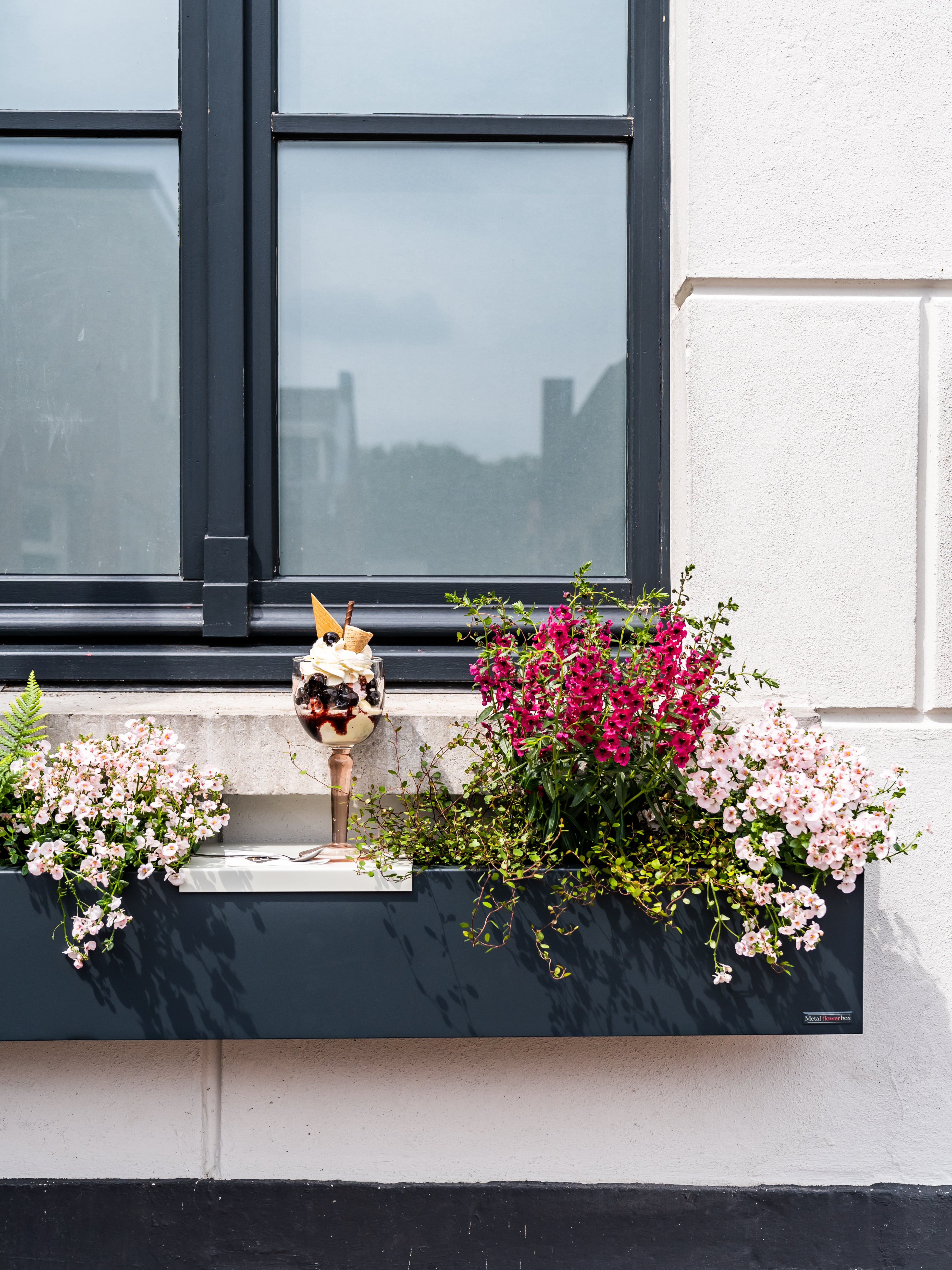 Strakke entree met moderne plantenbakken