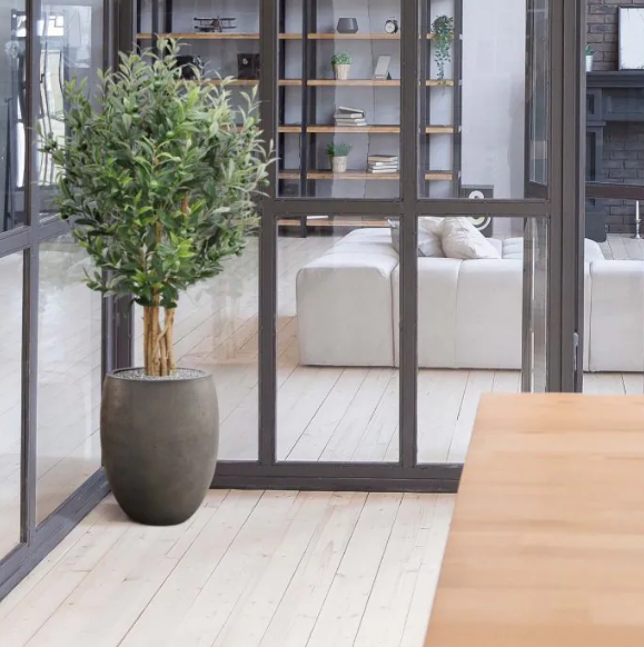 Moderne werkruimte met kunstplanten die zorgen voor een nette, duurzame en uitnodigende kantooromgeving.