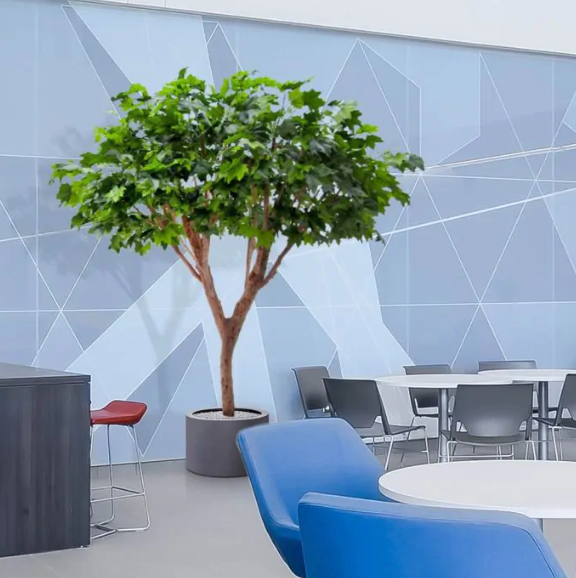 Moderne werkruimte met kunstplanten die zorgen voor een nette, duurzame en uitnodigende kantooromgeving.