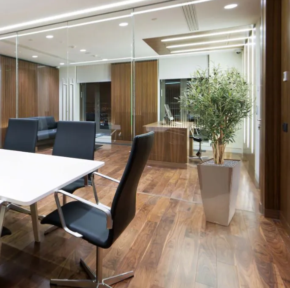 Moderne werkruimte met kunstplanten die zorgen voor een nette, duurzame en uitnodigende kantooromgeving.